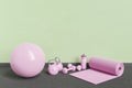 Pink yoga equipment in room with green wall