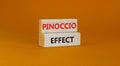 Pinoccio effect symbol. Concept words Pinoccio effect on wooden blocks on a beautiful orange background. Business and Pinoccio Royalty Free Stock Photo