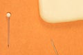 Pins with a ball and a bar of soap lie on an orange background from above