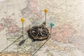 Pins and vintage compass on an old world map Royalty Free Stock Photo