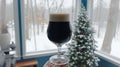 a pint of black beer in front of a Christmas tree. Royalty Free Stock Photo