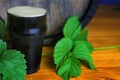 Pint of dark beer foam beautifully on a barrel with a leaf of hops background Royalty Free Stock Photo