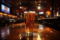 Pint of foaming beer in a glass on a bar counter