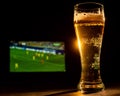 A pint of foaming lager and football on TV.