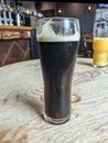 A Pint of Stout Beer on A Wooden Pub Table with a Glass of Orange Juice Royalty Free Stock Photo