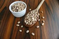 Pinto beans. Carioca beans in a wooden spoon with bowl with beans on wooden table. Top view. Brazilian culinary