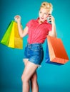 Pinup girl with shopping bags calling on phone Royalty Free Stock Photo