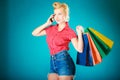 Pinup girl with shopping bags calling on phone Royalty Free Stock Photo