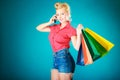 Pinup girl with shopping bags calling on phone Royalty Free Stock Photo