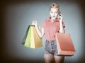 Pinup girl with shopping bags calling on the phone Royalty Free Stock Photo