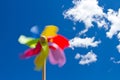 Pinwheel on blue sky with white clouds