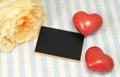 Pion-shaped rose, two red hearts and a black board