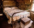 Master bedroom with a wrought iron bedstead in a pioneer cabin
