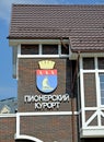PIONEER RESORT, RUSSIA. Fragment of the bus station building with the coat of arms of the city and name. Russian