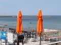 PIONEER, RUSSIA.Two beach orange umbrellas against the background of the Baltic Sea