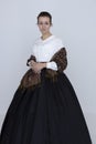 A Victorian woman wearing a white Garibaldi blouse and full, black skirt with a paisley blouse