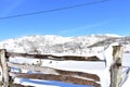 Winter landscape with snowy field and mountains and wooden fence. Blue sky, sunny day. Piornedo, Lugo, Galicia, Spain. Royalty Free Stock Photo