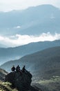 Pip Ivan, Ukraine - August 2, 2020: friends of three sitting on the rock at the top of the mountain enjoying the view