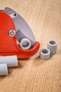 Pipe cutter with pipes on woodn board Royalty Free Stock Photo