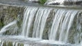 Pipe expelling water and water running and in a natural water spring