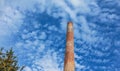 The pipe of a gas boiler house against the blue sky. No smoke comes out of the chimney. Energy crisis