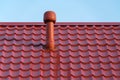 Pipe of a modern ventilation system on the roof of the house with metal tiles