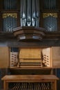 Pipe organ console with two keyboards or manuals, stop knobs, pedal board, and case facade in the St. Mary`s Church of Gudow,