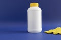 Pipe Plumber Drain Granules in White Plastic Bottle With Yellow Cap, Rubber Glove On Blue