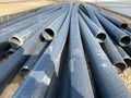 Gas polypropylene pipe in rolls on the street, black plastic pipes