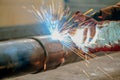 Pipe welding. The connection of the pipe with a clamp. Welder performs welding work semi-automatic electric arc welding Royalty Free Stock Photo