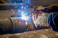 Pipe welding. The connection of the pipe with a clamp. Welder performs welding work semi-automatic electric arc welding Royalty Free Stock Photo