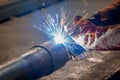 Pipe welding. The connection of the pipe with a clamp. Welder performs welding work semi-automatic electric arc welding Royalty Free Stock Photo