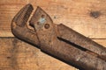 Pipe wrench on wood background. adjustable gas wrench. working instrument. tool for repair