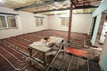 Pipefitter installing system of heating or underfloor heating installation. Water floor heating system interior