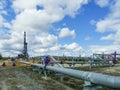 Pipeline collector of gas wells on the background of the drilling rig.