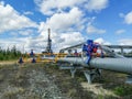 Pipeline collector of gas wells on the background of the drilling rig.