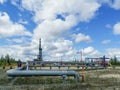 Pipeline collector of gas wells on the background of the drilling rig.