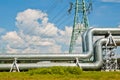 pipeline and power line support, in the photo pipeline and power line tower close-up against the background of blue sky and clouds