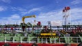 Pipelines system with crane on crude oil tanker at shipyard against white clouds and blue sky