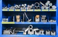 pipes, metal pieces and various metal parts for a CNC machine standing on a shelf Royalty Free Stock Photo