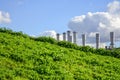 Pipes of the plant from which there is white smoke on the background of a green lawn Royalty Free Stock Photo