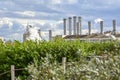 The pipes of the plant from which white smoke comes on the background of green trees Royalty Free Stock Photo