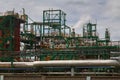 Pipes and structures of an oil refinery against a cloudy sky Royalty Free Stock Photo