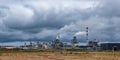 Pipes of woodworking enterprise plant sawmill against a gloomy gray sky. Air pollution concept. Panorama of industrial landscape