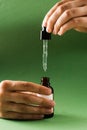 Pipette with Cannabidiol CBD oil in hand. CBD oil from the Cannabis plant to help reduce pain, anxiety, and sleep