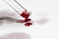 pipette with wine drops on white sheet with stains