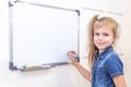 Pipil girl standing near white board. Learning and school concept Royalty Free Stock Photo