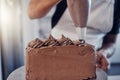 Piping, bakery and hands of baking a chocolate cake in a kitchen or pastry chef cooking a recipe. Food, dessert and cook Royalty Free Stock Photo