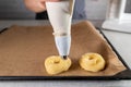 Piping choux pastry with a piping bag for making crullers