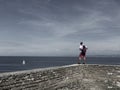 PIRAN, SLOVENIA - 08/15/2020: Young caucasian man on brick wall looking at sea